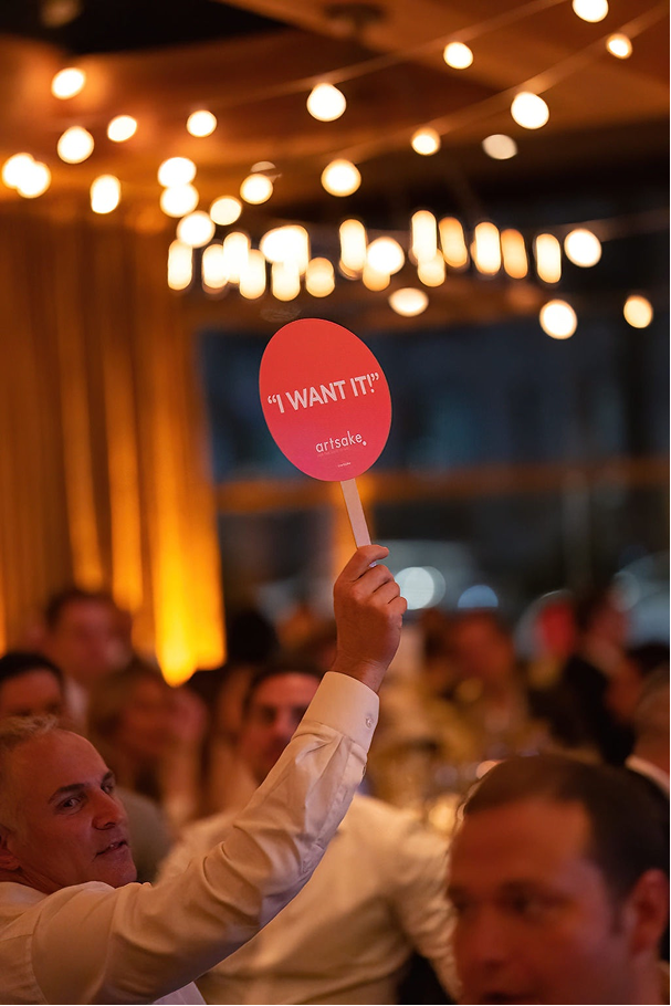 Guest holding auction paddle